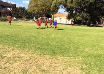 1st and 2nd grade Aussie friends playing Australian Rules Football
