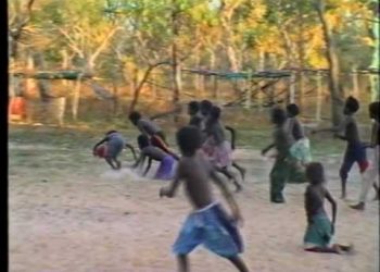 Aboriginal kids playing Aussie Rules football