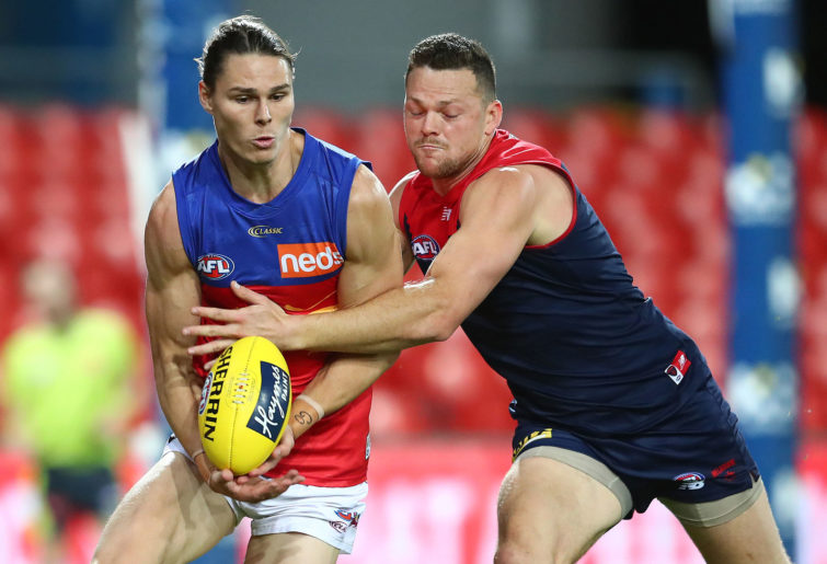 Eric Hipwood of the Lions is tackled by Steven May of the Demons