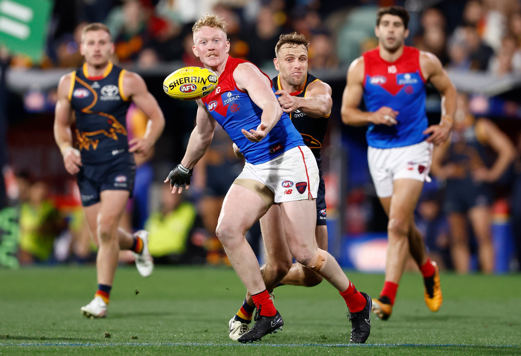 Clayton Oliver of the Demons is tackled by Brodie Smith of the Crows